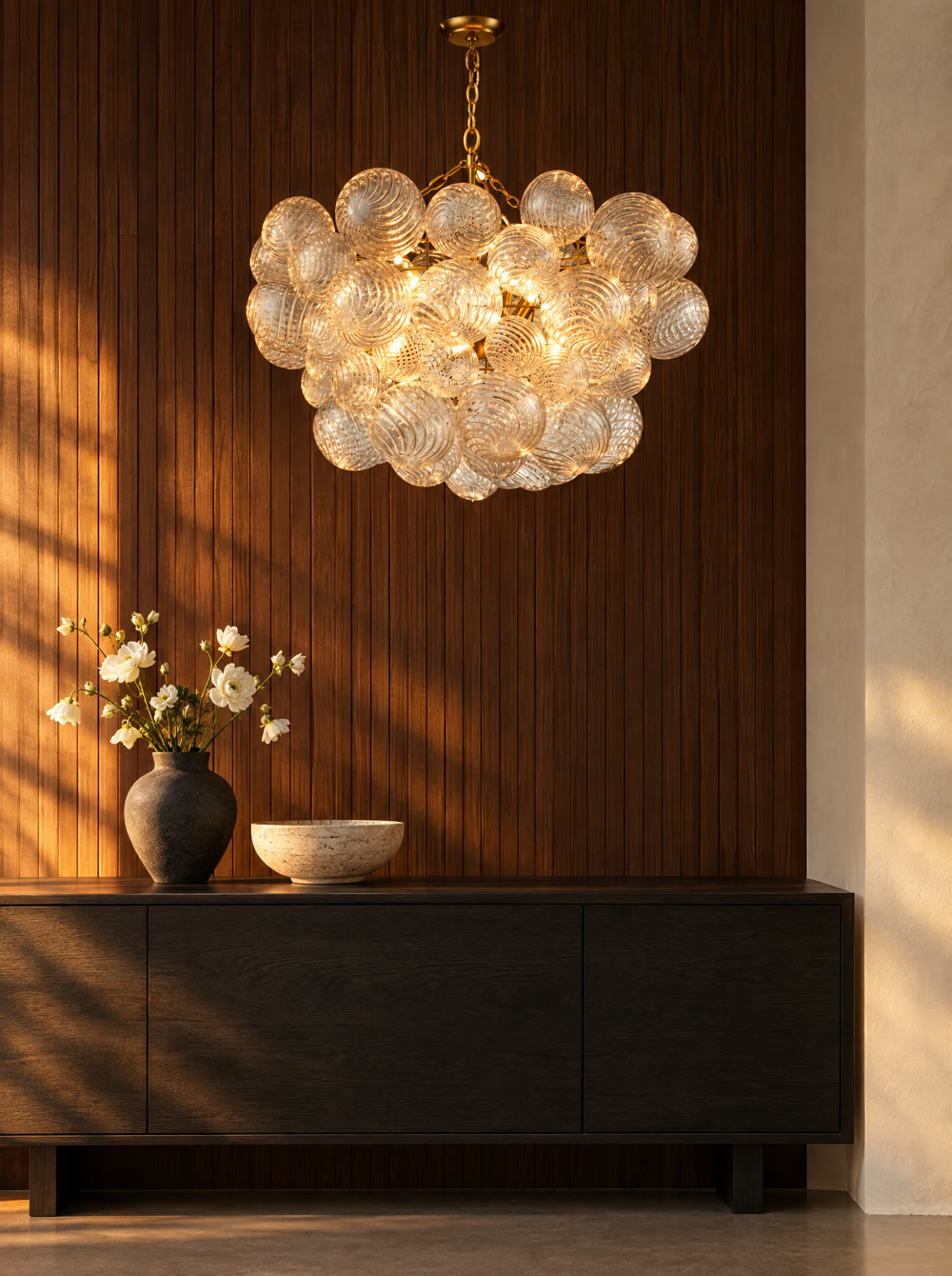 A glowing glass chandelier in a warm room at golden hour.